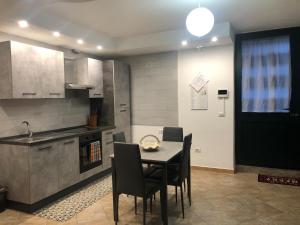 a kitchen with a table and chairs in a kitchen at Casa Graziosa - Casa vacanze a Policoro in Policoro
