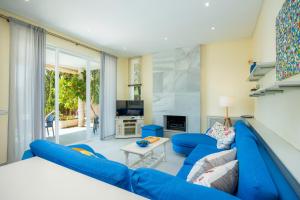 a living room with a blue couch and a table at Des Port - Vistas al mar in Portopetro