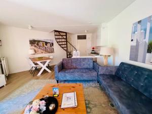 ein Wohnzimmer mit einem blauen Sofa und einem Tisch in der Unterkunft Liguster 8 in Nieuwvliet