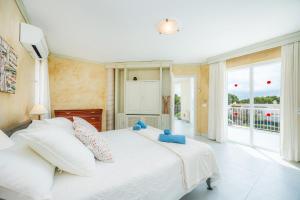 a bedroom with a white bed and a large window at Des Port - Vistas al mar in Portopetro +26 photos