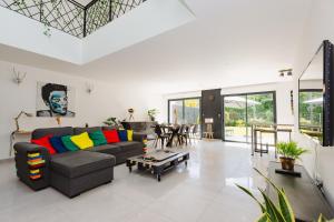 a living room with a couch and a table at La Villa Pop & Steel - maison avec 4 chambres in Orgères
