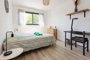 a bedroom with a bed and a table and a chair at La Villa Pop & Steel - maison avec 4 chambres in Orgères