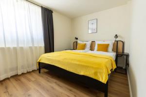 a bedroom with a bed with yellow sheets and a window at Happy Place am Waldrand in Plettenberg