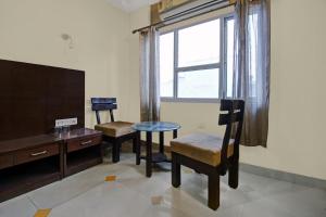 a room with two chairs and a table and a tv at Super Townhouse OAK HOTEL Heritage Heights in Jaipur