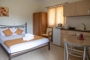 a bedroom with a bed and a table and a kitchen at Bella Meliti in Lygia
