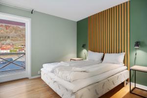 a bedroom with a bed and a large window at Flåmsbrygga Apartments in Flåm