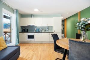 a kitchen and living room with a table and a couch at Flåmsbrygga Apartments in Flåm