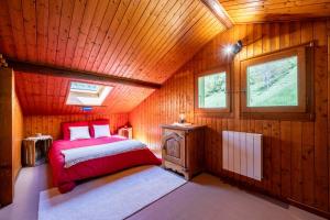 a bedroom with a bed in a wooden cabin at Le Grenier de Fernand - vue montagne in Saint-Jean-de-Sixt