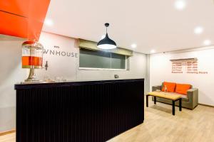 a bar in a room with a couch and a table at Collection O Near Kohat Enclave Metro Station in New Delhi