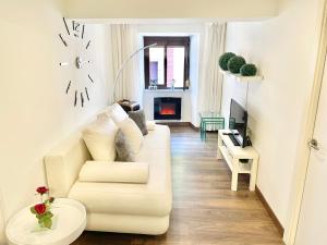 a living room with a white couch and a fireplace at La Casina de Cudillero in Cudillero