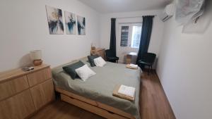 Un dormitorio con una cama y una cómoda. en IKON Vendégház, en Siófok