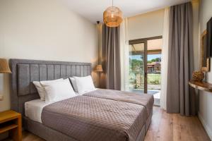 een slaapkamer met een groot bed en een raam bij Phos Elegant Residences by Konnect, 400m to the beach in Dassia