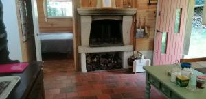a living room with a fireplace in a house at La palombière in Saint-Symphorien