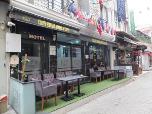 un restaurante con sillas y mesas frente a un edificio en clove silvana hotel, en Eskiömerler