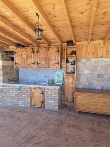 a kitchen with wooden cabinets and a sink at Слънчевите Къщи-село Китка in Kitka
