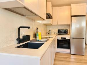 eine Küche mit Spüle und Kühlschrank in der Unterkunft Villa Nautica Puerto Rico by Alquiler de Súeño in Puerto Rico de Gran Canaria