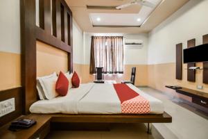 a bedroom with a large bed and a television at Hotel O Hadoti Resort in Bhilwara