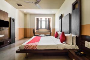 a bedroom with a large bed with red pillows at Hotel O Hadoti Resort in Bhilwara +18 photos