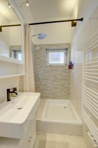 a white bathroom with a sink and a shower at Bungalow - Kinderspielplatz - Garten mit Feuerstelle in Timelkam +31 photos