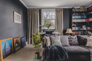 a living room with a couch and a book shelf at Little Redlap - Delightful views near Dartmouth in Dartmouth