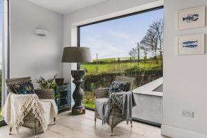 a living room with chairs and a large window at Little Redlap - Delightful views near Dartmouth in Dartmouth