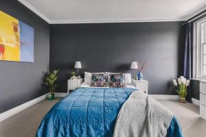 a bedroom with a blue bed and a gray wall at Little Redlap - Delightful views near Dartmouth in Dartmouth