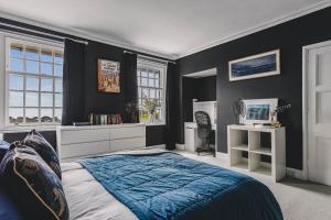 a bedroom with a blue bed and black walls at Little Redlap - Delightful views near Dartmouth in Dartmouth