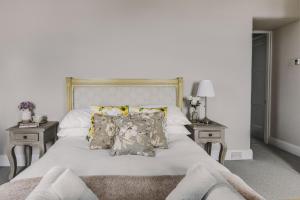 a bedroom with a white bed with pillows and two tables at Little Redlap - Delightful views near Dartmouth in Dartmouth