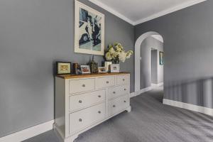 a bedroom with a white dresser and a wall at Little Redlap - Delightful views near Dartmouth in Dartmouth