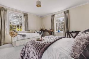 a bedroom with two beds and two windows at Little Redlap - Delightful views near Dartmouth in Dartmouth