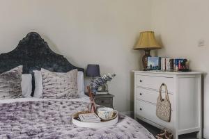 a bedroom with a bed and a nightstand with a tray on it at Little Redlap - Delightful views near Dartmouth in Dartmouth