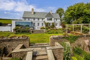 an exterior view of a house with a stone wall at Little Redlap - Delightful views near Dartmouth in Dartmouth