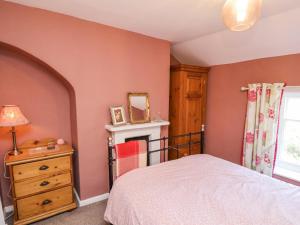 una camera da letto con un letto, un comò e una finestra di 2 Whinstone Cottage a Whitby