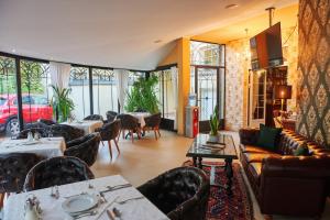 Un restaurante con mesas y sofás y un coche. en Garni Hotel Andric, en Sombor