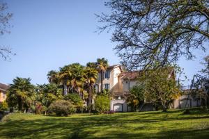a house on a hill with palm trees at Maison Tournesol Massages Pau Jurançon in Gan