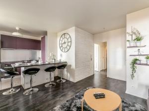 Una cocina con taburetes de bar y un reloj en la pared. en Appartement Le Petit Monde Magique, en Bailly-Romainvilliers 7 fotos más