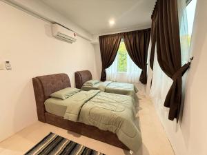 a bedroom with two beds and a window at OT7 Eleven Santubong Suites in Kuching