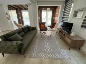 un soggiorno con un divano e una TV di Derya Beach Agullu Villa 3 a Kaş
