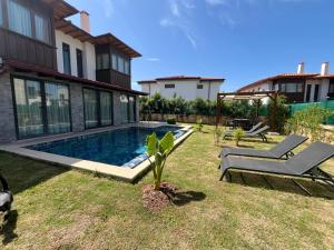 un cortile con piscina e una casa di Derya Beach Agullu Villa 3 a Kaş