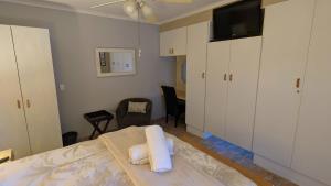 a bedroom with a bed and a tv and cabinets at Amarachi Guesthouse in Swakopmund