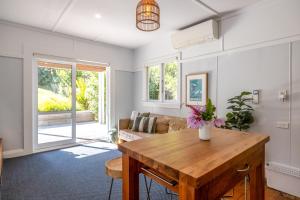 ein Wohnzimmer mit Tisch und Couch in der Unterkunft Hideaway Cottage in Oneroa