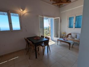 a living room with a table and chairs and a couch at Loft apartment with sea view in Chrani