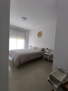 Un dormitorio con una cama y un reloj en la pared. en Apartamento San Roque, en Finisterre