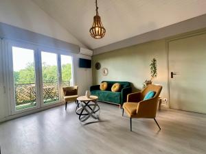 sala de estar con sofá verde y 2 sillas en Duplex COSY - familial spacieux, en Mont-de-Marsan