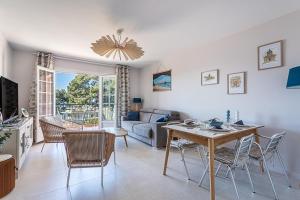 a living room with a table and chairs at Beau Rivage - 7min à pied de la Plage in Carqueiranne