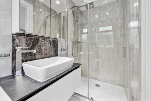 a bathroom with a sink and a shower at Spacious 5BR for Work Crews Parking & WiFi in Luton +63 photos