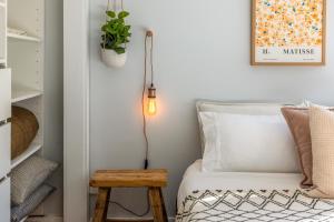 ein Schlafzimmer mit einem Bett mit einem Tisch und einer Lampe in der Unterkunft Hideaway Cottage in Oneroa