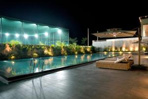 a swimming pool at night with a building at SERENE WOODS in Srīkākulam