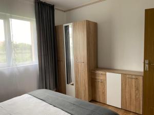 a bedroom with a bed and a cabinet and a window at Apartament Cristian in Cîmpia Turzii
