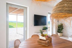 a dining room with a wooden table and a television at Podere del Bagnolino - Appartamento Belvedere in Santa Luce